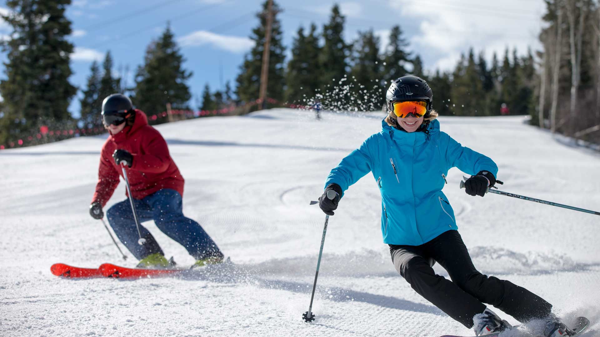 Two skiers carving on piste
