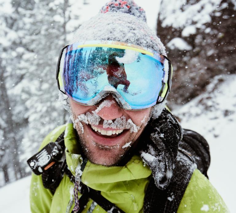 Man in backcountry wearing goggles with mirrored lenses