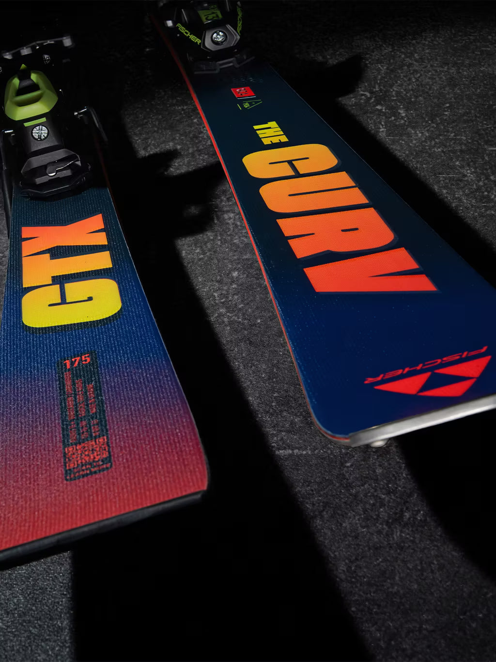 Two skis with 'GTX' and 'CURV' branding on a dark surface