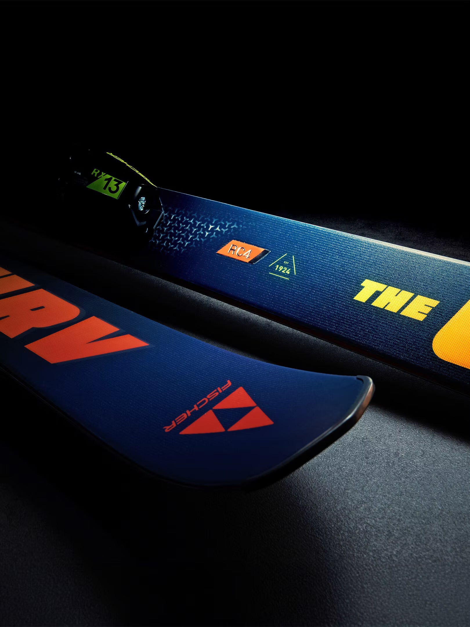 Close-up of a blue ski with visible branding on a dark background