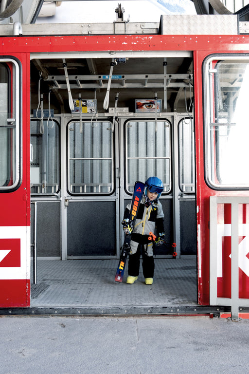 Junior Skier Standing in Tram Wearing Yellow Fischer Two Ski Boots